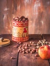 Nuts peanuts in a tall decorative jar with a pattern and a red apple