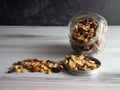 Nuts, seeds and dried fruits spilling out of a clear glass jar into the lid and onto the table!  Healthy, nutrient packed good Royalty Free Stock Photo