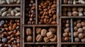 nuts, such as walnuts and hazelnuts, presented in wooden boxes, with a background of various whole peanuts arranged on Royalty Free Stock Photo