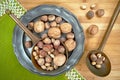 Nuts of various types on a metal plate, from above on a wooden board