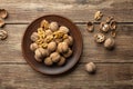 Nuts. Walnut kernels and whole walnuts on a table. Wooden background. Royalty Free Stock Photo