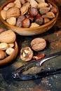 nuts in wooden bowls and a steel nut cracker. Close-up, selective focus Royalty Free Stock Photo