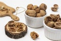 Nutshells and whole nuts in white bowls. Walnut kernels on a stump Royalty Free Stock Photo