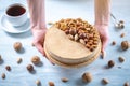 Nutty caramel cheesecake with topping of walnut, almond, hazelnut and macadamia on a wooden background