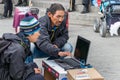 An male Inuit - eskimo with his son trying a laptop at the street market in Nuuk.