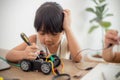 nventive kids learn at home by coding robot cars and electronic board cables in STEM. constructing robot cars at home