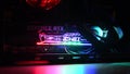 NVidia GeForce RTX 3080 inside gaming PC tower with colorful backlights in darkness