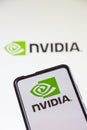 Nvidia logo of the software company which designs graphics processing units GPU on a mobile phone and computer screen