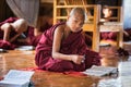 Asian child monk learning from his school book