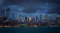 NYC Cityscape with Stormy Cloudy Blue Sky in Background. The Smoke Stacks on the left in the background