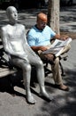 NYC: Man Reading Newspaper & Sculpture Royalty Free Stock Photo