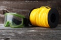 Nylon grass trimmer line and safety goggles on an old wooden background