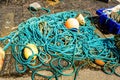 Nylon Ropes With Buoys On The Floor Next To A Blue Plastic Box With Stones On The Pier