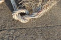 Nylon ship ropes tied to knot on cement flooring at port closeup.