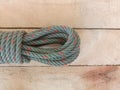 Nylon ship ropes tied to knot with copy space isolated on wooden background closeup.