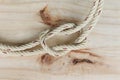 Nylon ship ropes tied to knot isolated on wooden background closeup.