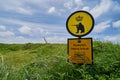 Warning sign in front of an army training area in the dunes of the North Sea coast in Denmark Royalty Free Stock Photo