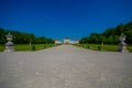 Nymphenburg, Germany - July 30, 2015: Beautiful palace as seen from distance with statues on both sides of avenue