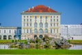 Nymphenburg, Germany - July 30, 2015: Palace facade as seen from straight ahead across lake, water visible and beautiful ble sky