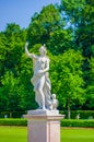 Nymphenburg, Germany - July 30, 2015: Sculpture of woman, beautiful sunny day, green grass and bushes in palace gardens