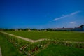 Nymphenburg, Germany - July 30, 2015: Very big grass field bathing with sunshine, some buildings in background, palace