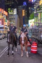 NYPD police officers on horseback in Times Square, New York City. Mounted Police patrolling the night in Times Square Royalty Free Stock Photo