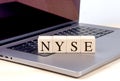NYSE word on wooden block on laptop , business concept