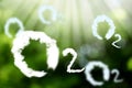 O2 molecules made with clouds and blurred view of green background. Oxygen release concept