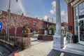 O`neal Plaza with red brick buildings, black metal fences, bare winter trees and green plants along Veterans Memorial Hwy with