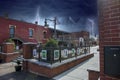 O`neal Plaza with red brick buildings, black metal fences, bare winter trees and green plants along Veterans Memorial Hwy