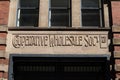 O-Operative Wholesale Society Ltd carved stone lintel sign over entranceway in old red brick and stone building