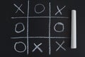 O X Game on black chalk board Royalty Free Stock Photo