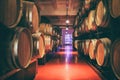 Oak barrels with wine in dark cellar. Modern production of wine with the observance of age-old traditions. Royalty Free Stock Photo
