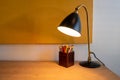 Oak colored desk with lamp and box of colored pencils Royalty Free Stock Photo