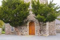 The oak door of Drumbo Parish Church flanked by two ancient Juniper trees in the County Down village of Drumbo in Northern Ireland