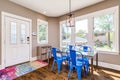 A dining room with a glass table and blue chairs.