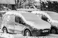 OAKHAM, RUTLAND, ENGLAND- 25 JANUARY 2021: Royal Mail delivery vans covered in snow black and white photo