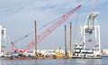 Tugboat pushing barge with heavy equipment past the Port of Oakland