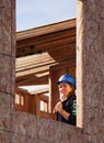 Woman looks out unfinished window of home for Habitat For Humanity