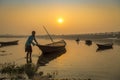 An oarsman tries to tow his boat to shore at sunset on river Damodar.