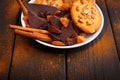 Biscuits, black chocolate on a plate on the table. Around the plates sprinkled with cinnamon. Side view.