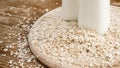 Oat flakes and bottle of fresh milk on a wooden board Royalty Free Stock Photo