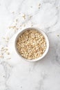 Oat flakes in bowl on white background. Copy space. Royalty Free Stock Photo