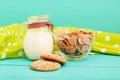 Oat flakes and cookies with jug of milk on blue wooden kitchen. Tablecloth in polka dots. Copy space and selective focus