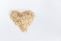 Oat flakes forming a heart shape on white background, conceptual image of good food for health. Royalty Free Stock Photo