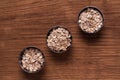 Oat flakes in metal bowl on brown wooden table Royalty Free Stock Photo