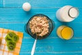 Oat flakes with milk and kiwi bowl with spoon on blue wooden background, top view Royalty Free Stock Photo