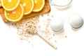 Oat flakes plate with milk, orange, eggs on a wooden white table. Top view of healthy oat flakes breakfast. Copy space Royalty Free Stock Photo