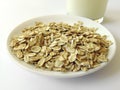 Oat flakes on a plate next to a glass of milk