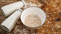 Oat flakes in white bowl and bottles of fresh milk Royalty Free Stock Photo